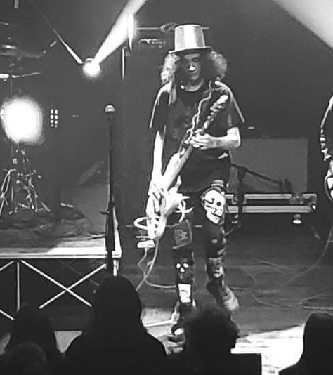 Milo Powers playing bass on stage in black and white